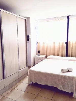 a bedroom with two beds and a large window at Monoambiente para 2 personas con baño privado in Cordoba