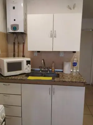 a kitchen counter with a microwave and a sink at Monoambiente para 2 personas con baño privado in Cordoba