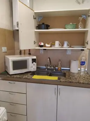 a kitchen counter with a microwave and a sink at Monoambiente para 2 personas con baño privado in Cordoba
