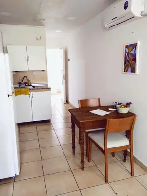 a kitchen with a wooden table and a kitchen with a refrigerator at Monoambiente para 2 personas con baño privado in Cordoba