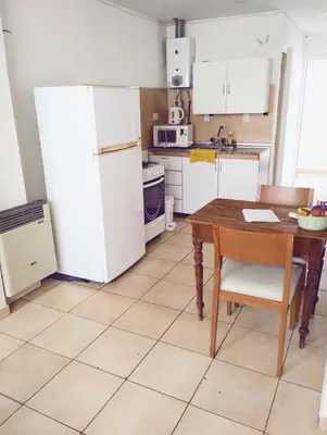 a kitchen with a table and a white refrigerator at Monoambiente para 2 personas con baño privado in Cordoba
