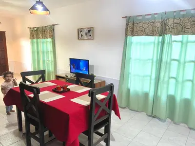 a dining room with a table with a red table cloth at Cabaña en el Centro de Mina Clavero in Mina Clavero
