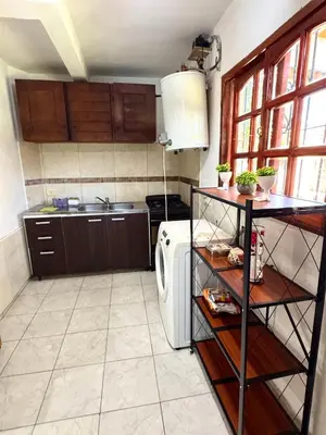 a kitchen with a stove and a refrigerator at Cabaña en el Centro de Mina Clavero in Mina Clavero