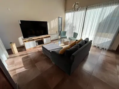 a living room with a couch and a flat screen tv at Andelka-Chumamaya Merlo San Luis in Merlo