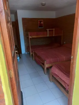 a room with two bunk beds and a tile floor at Hostería Reserva Serrana in Mina Clavero