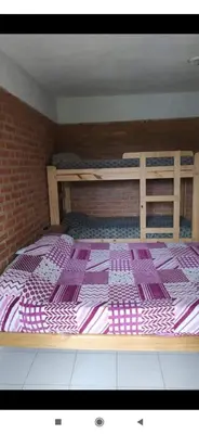 a large bed in a room with a brick wall at Hostería Reserva Serrana in Mina Clavero