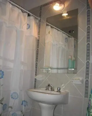 a bathroom with a sink and a shower with a mirror at El Encuentro in Tanti