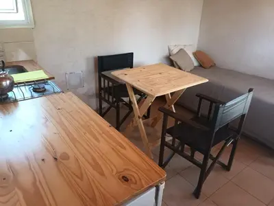 a table and chairs in a room with a bed at El Encuentro in Tanti