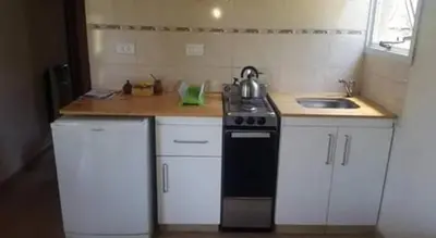 a small kitchen with a stove and a sink at El Encuentro in Tanti