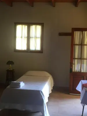 a bedroom with a bed and two windows at Posada Tanti El Durazno in Tanti