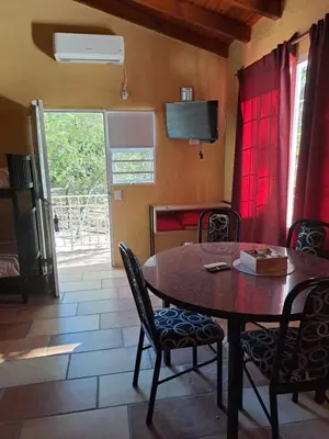 a dining room with a table and chairs and a window at Complejo Los Manantiales in Alta Gracia