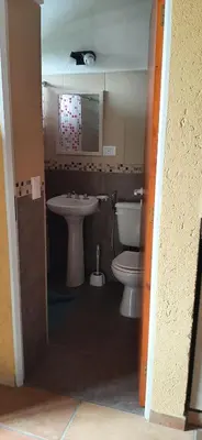 a bathroom with a toilet and a sink at Complejo Los Manantiales in Alta Gracia