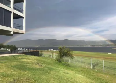 a rainbow in the sky over a body of water at Villa General Belgrano - Puerto del Águila in Potrero de Garay