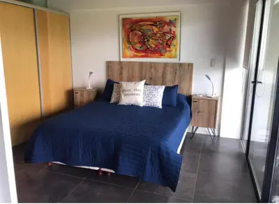 a bedroom with a bed with blue sheets and pillows at Villa General Belgrano - Puerto del Águila in Potrero de Garay