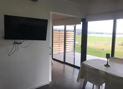 a living room with a table and a flat screen tv at Villa General Belgrano - Puerto del Águila in Potrero de Garay
