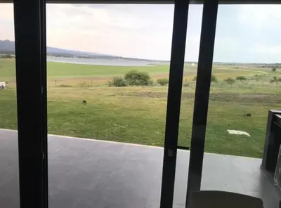 a view of a field from a glass window at Villa General Belgrano - Puerto del Águila in Potrero de Garay