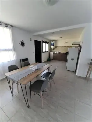 a table and chairs in a room with a kitchen at Complejo Dos Osos in Villa General Belgrano