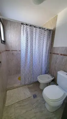 a bathroom with a toilet and a shower at Complejo Dos Osos in Villa General Belgrano