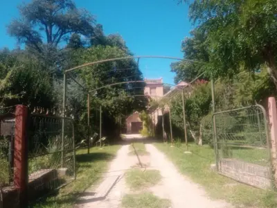 an empty street with a gate and a building at Cabaña en quinta la aurora in Mina Clavero