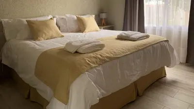 a large white bed with two towels on it at Morada del Cóndor - Cabañas Serranas in Merlo