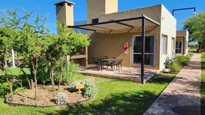 a house with a patio with a table and chairs at Morada del Cóndor - Cabañas Serranas in Merlo