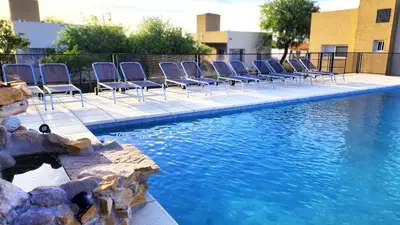 a row of chairs sitting next to a swimming pool at Morada del Cóndor - Cabañas Serranas in Merlo