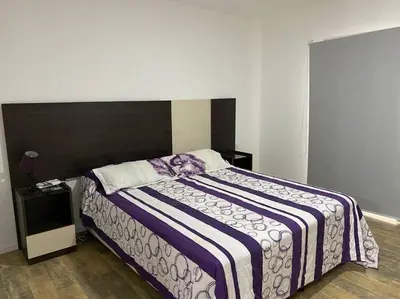 a bedroom with a bed with a purple and white blanket at Casa frente al lago en barrio privado in Almafuerte