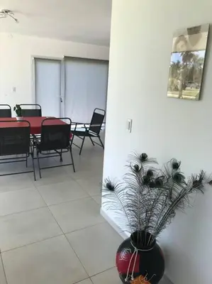 a living room with a vase with a plant in it at Casa frente al lago en barrio privado in Almafuerte