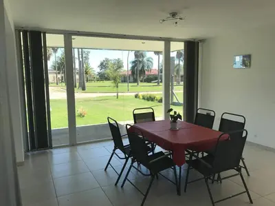 a dining room with a wooden table and chairs at Casa frente al lago en barrio privado in Almafuerte