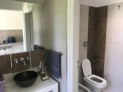 a bathroom with a black sink and a toilet at Casa frente al lago en barrio privado in Almafuerte