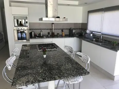 a kitchen with a table with chairs and a stove at Casa frente al lago en barrio privado in Almafuerte