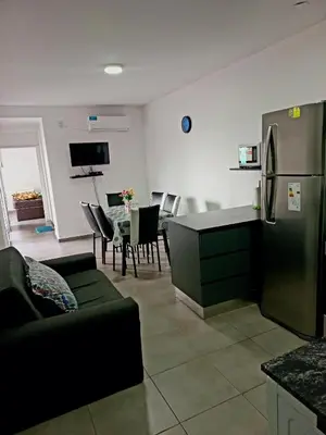 a living room with a refrigerator and a table with chairs at Apartamento Faro de General Paz in Cordoba