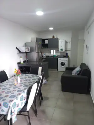 a dining room and kitchen with a table and chairs at Apartamento Faro de General Paz in Cordoba