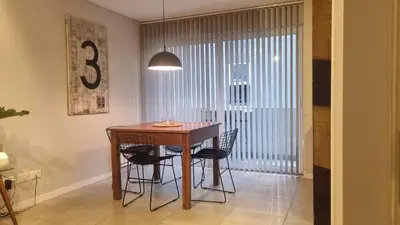 a dining room with a wooden table and black chairs at PISO TRES. Depto de categoría en cofico. C/Cochera in Cordoba