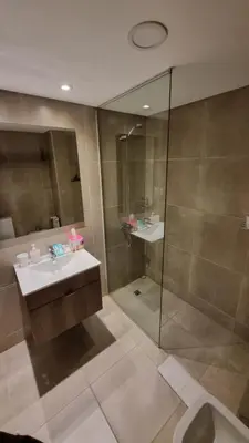 a bathroom with a sink and a glass shower at PISO TRES. Depto de categoría en cofico. C/Cochera in Cordoba