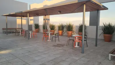 a patio with tables and chairs and plants on a roof at PISO TRES. Depto de categoría en cofico. C/Cochera in Cordoba