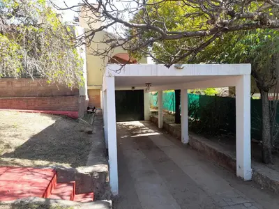 a white entrance to a garage in a yard at ESTANCIA VIEJA (CARLOS PAZ) in Estancia Vieja