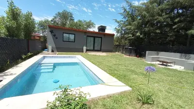 a backyard with a swimming pool and a house at La Lola in Villa del Dique