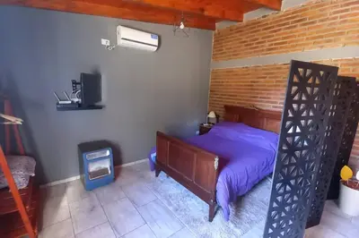 a bedroom with a bed and a brick wall at La Lola in Villa del Dique