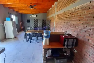 a room with a brick wall and tables and chairs at La Lola in Villa del Dique