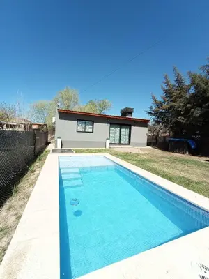 a swimming pool in front of a house at La Lola in Villa del Dique