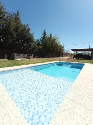 a swimming pool with blue water in a yard at La Lola in Villa del Dique