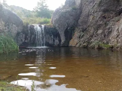 a waterfall in the middle of a body of water at Bela Vista Casa Serrana, Golpe de Agua in Los Reartes