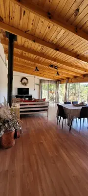 a large room with a wooden ceiling and a table at Bela Vista Casa Serrana, Golpe de Agua in Los Reartes