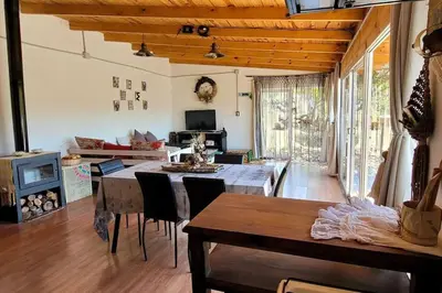 a living room with a table and chairs and a couch at Bela Vista Casa Serrana, Golpe de Agua in Los Reartes