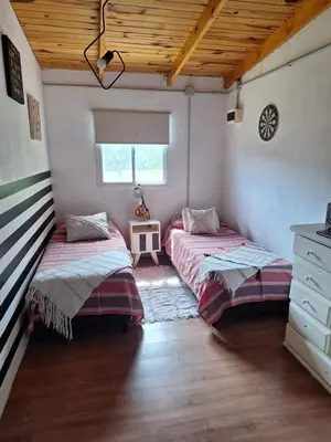 two beds in a room with a wooden ceiling at Bela Vista Casa Serrana, Golpe de Agua in Los Reartes