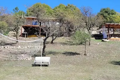 a hammock in a field next to a house at Bela Vista Casa Serrana, Golpe de Agua in Los Reartes