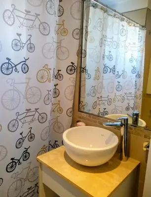 a bathroom with a sink and a shower curtain with bikes on it at Departamento a estrenar con piscina con cochera opcional in Río Cuarto