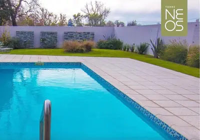 a swimming pool with blue water in a yard at Departamento a estrenar con piscina con cochera opcional in Río Cuarto