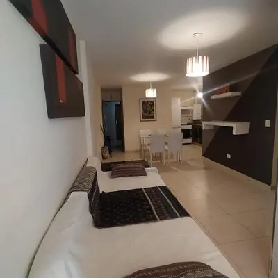 a living room and kitchen with two beds in a room at Departamento zona Nuevocentro Shopping in Cordoba
